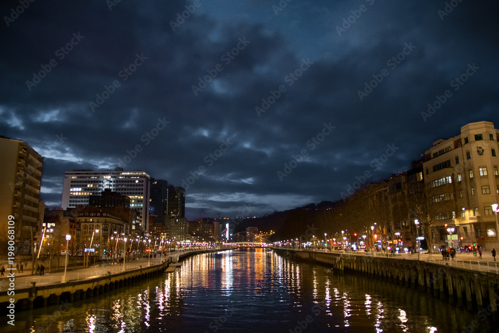 Magical bridge and river illuminated at night in Bilbao. Spain