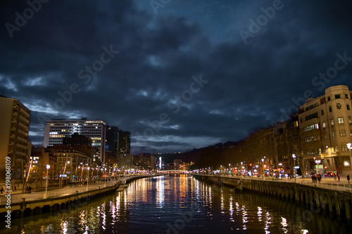 Magical bridge and river illuminated at night in Bilbao. Spain