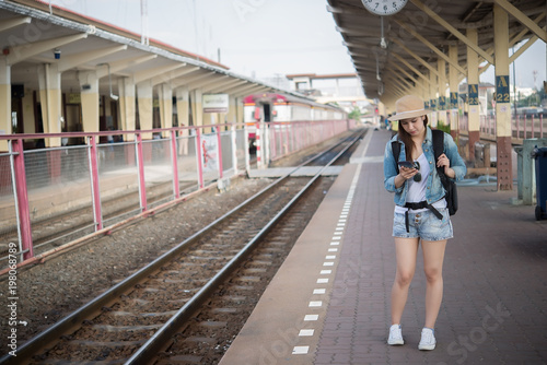 Asian tourist wait train at train station,thailand hipster man go to travel