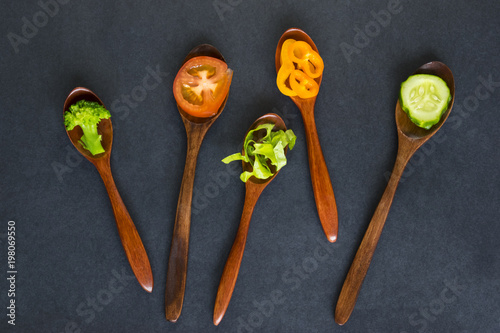 Wooden spoons with healthy food on the dark background.