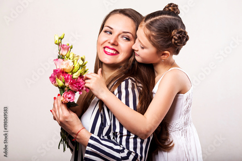 daughter gives flowers to her mother on her mother's day © Rock and Wasp