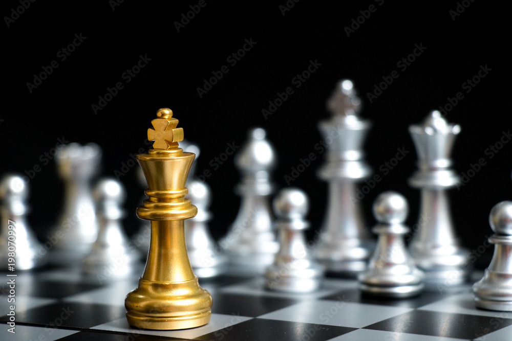 Gold King in chess game face with the another silver team on black background (Concept for company strategy, business victory or decision) Gold King in chess game face with the another silver team on black background (Concept for company strategy, business victory or decision)