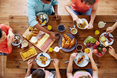 Print op canvas food, eating and family concept - group of people having breakfast and sitting a