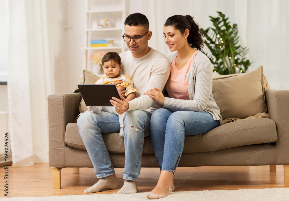 family, technology, parenthood and people concept - happy mother and father showing tablet pc computer to baby daughter at home family, technology, parenthood and people concept - happy mother and father showing tablet pc computer to baby daughter at home