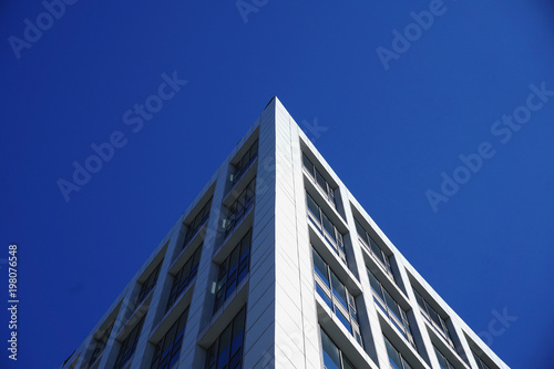 Modern building with windows isolated on blue sky background. 