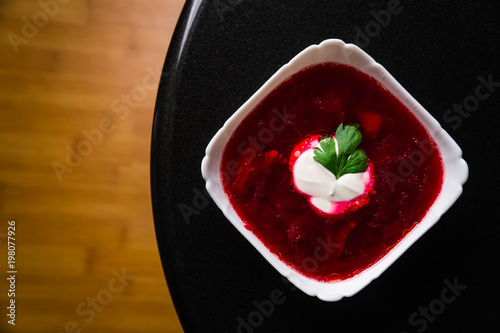 Borscht. Red soup in bowl with sour cream, isolated on wooden background. Close-up. Top view, vegetable, vegetarian, vintage, copyspace