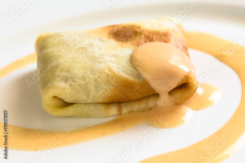 Hungarian Hortobagyi Palacsinta or Crepe a la Hortobagy savory crepe with mincemeat and paprika cream sauce, photographed with natural light (Selective Focus on the front of the crepe)