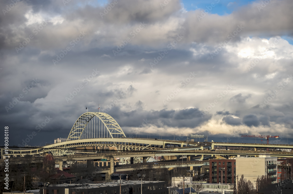 Obraz premium Urban Portland Oregon skyline with arch bridge and clouds