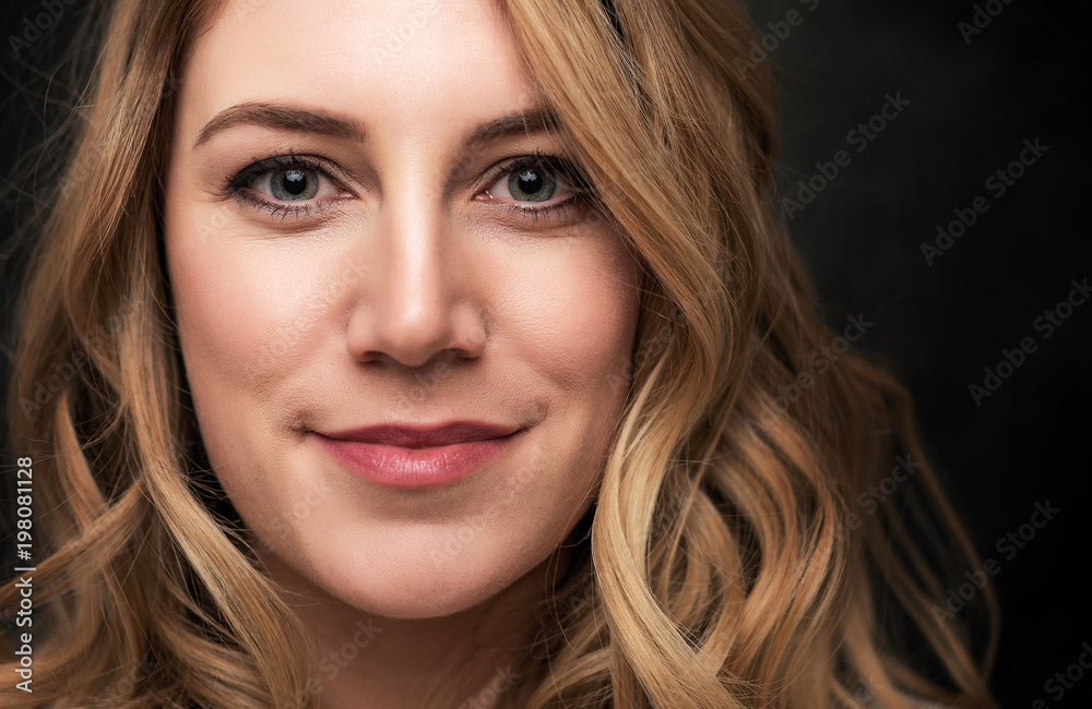 Portrait of an attractive young blonde woman on a black background. Portrait of an attractive young blonde woman on a black background.
