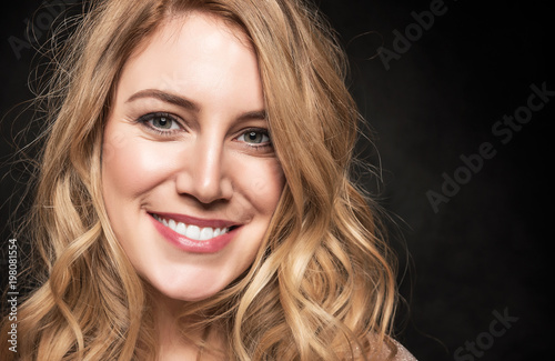 Portrait of an attractive young blonde woman on a black background.