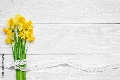 Fototapeta Naklejka Na Ścianę i Meble -  spring flower bouquet of yellow narcissus flowers over white wooden table
