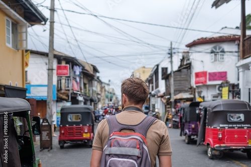 man traveling walking with backpack at small twon Galle in Sri Lanka