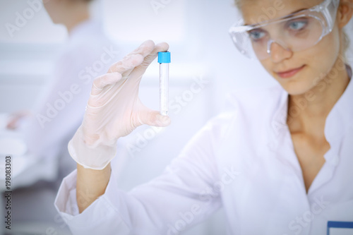 Female scientific researcher in laboratory studying substances or blood sample. Medicine and science concept