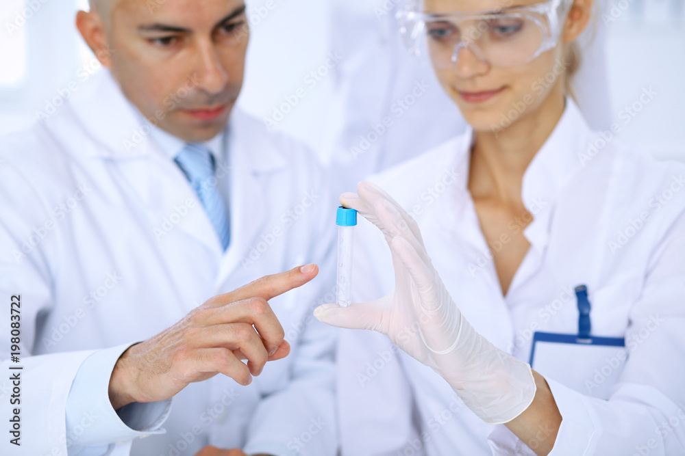 Team of scientific researchers in laboratory studying substances or blood sample. New vaccine for pharmacology industry is s almost ready. Medicine and science concept Team of scientific researchers in laboratory studying substances or blood sample. New vaccine for pharmacology industry is s almost ready. Medicine and science concept