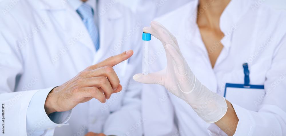 Team of scientific researchers in laboratory studying substances or blood sample. New vaccine for pharmacology industry is s almost ready. Medicine and science concept Team of scientific researchers in laboratory studying substances or blood sample. New vaccine for pharmacology industry is s almost ready. Medicine and science concept
