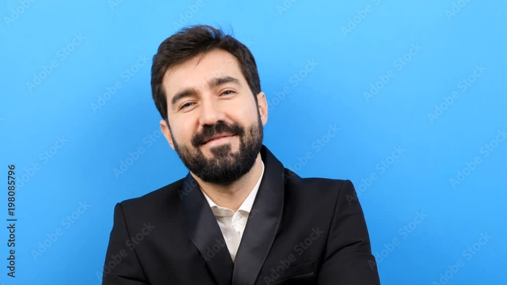 Businessman in formal suit smiling to the camera on blue background Businessman in formal suit smiling to the camera on blue background