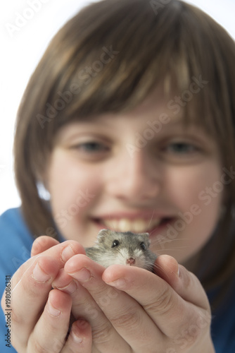a happy litle girl with a cute hamster isolated on white background