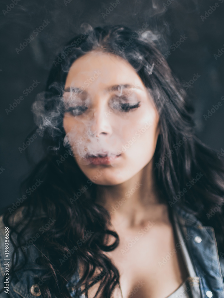 Woman Smoking a Cigarette on Black Background Woman Smoking a Cigarette on Black Background