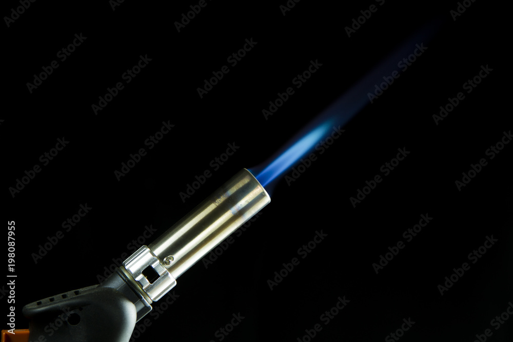 A blue blowtorch tool in action with his blue flame A blue blowtorch tool in action with his blue flame