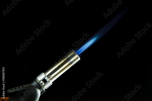 A blue blowtorch tool in action with his blue flame photo