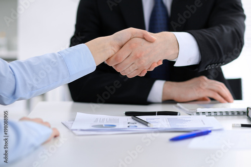 Close Up of unknown business people shaking hands while finishing up a meeting. Handshaking, agreement or success concept in people communication