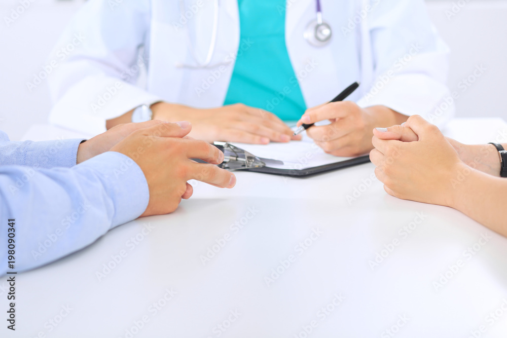 Doctor and patient couple are discussing something, just hands at the table Doctor and patient couple are discussing something, just hands at the table