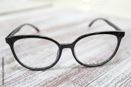 Women's fashionable eyeglass frame on white wooden background