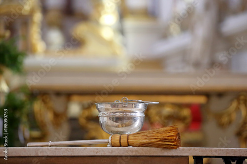 Church interior with sprinkler and holy water during Easter with empty space for text
