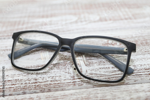 Fashionable men's eyeglass frame on white wooden background
