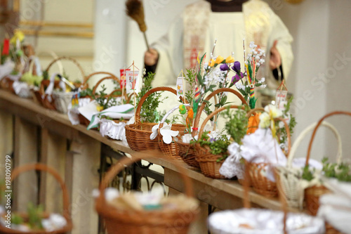 Tableau sur toile Consecration of Easter food, cakes, eggs and other dishes in the church
