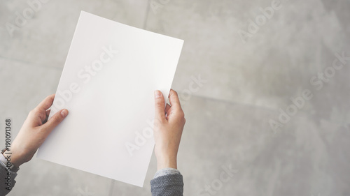 Person holding white empty paper photo
