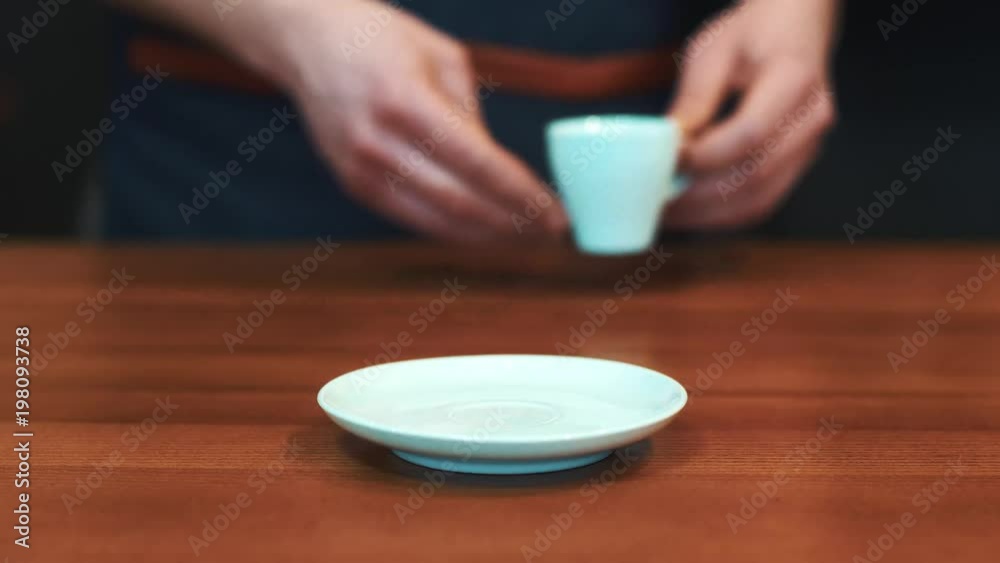 Barista serving a cup of coffee to camera Barista serving a cup of coffee to camera