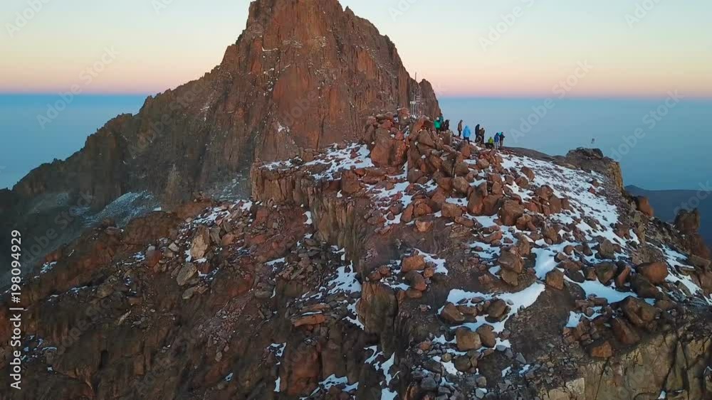 aerial view of unrecognizible climbers on summit of the Lenana peak of Mount Kenya during sunrise