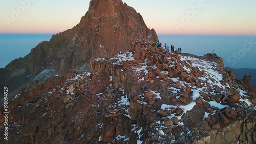aerial view of unrecognizible climbers on summit of the Lenana peak of Mount Kenya during sunrise