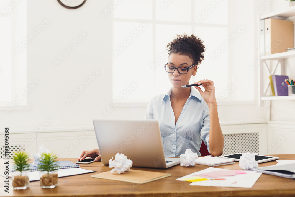 Serious business woman working on laptop at office Serious business woman working on laptop at office