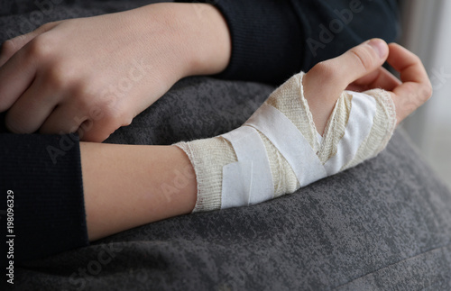 Child hand with gauze bandage on it.