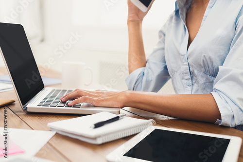 Female hands working on laptop with blank screen