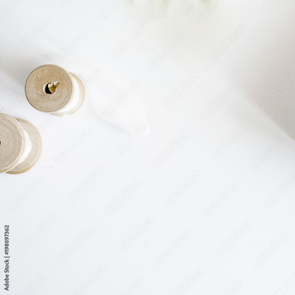 White background with silk ribbon on wooden spool