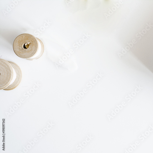 White background with silk ribbon on wooden spool