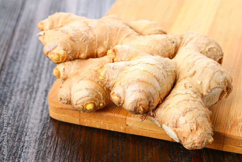 Spicy root of ginger on a wooden table.