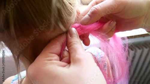 The girl is plaited with colored African braids. photo