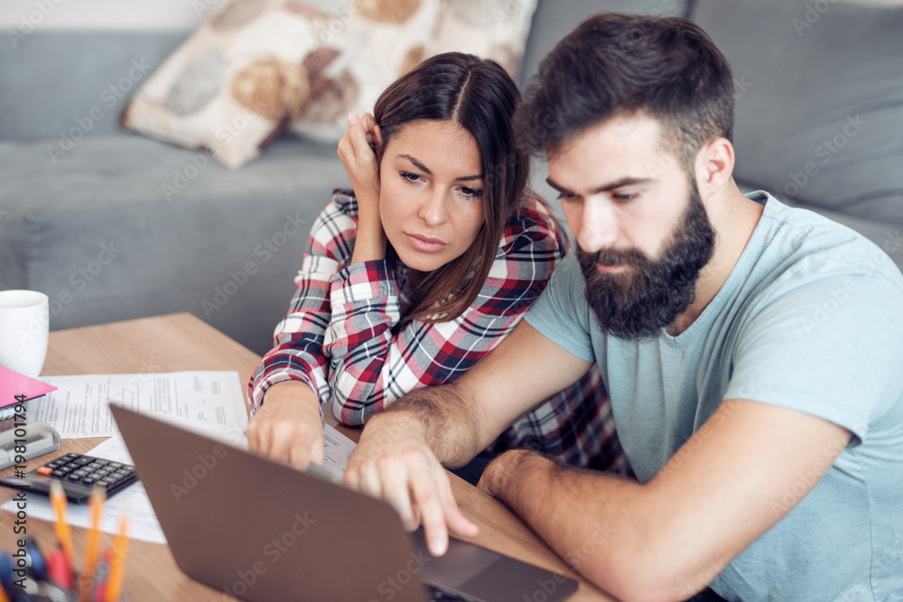 Couple calculating bills at home Couple calculating bills at home