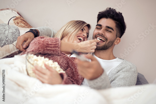 Lovely couple watching television in their home
