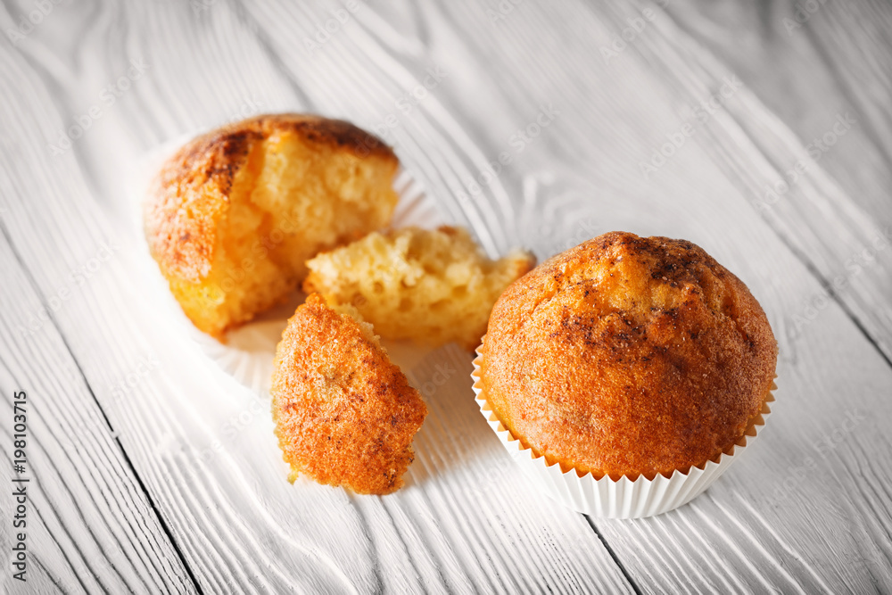 Classic muffins on a wooden old white background in a white wrapper. Classic muffins on a wooden old white background in a white wrapper.