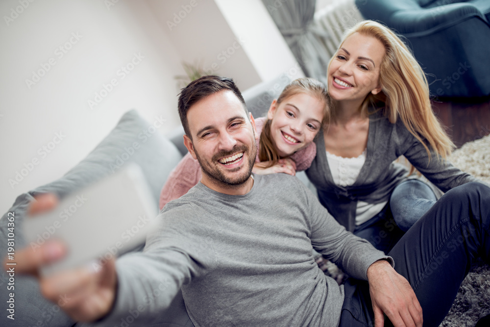 Happy family taking selfie in their house