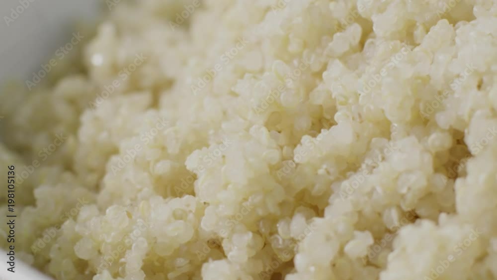 Vegan diet: tracking shot of a bowl of cooked quinoa in close up