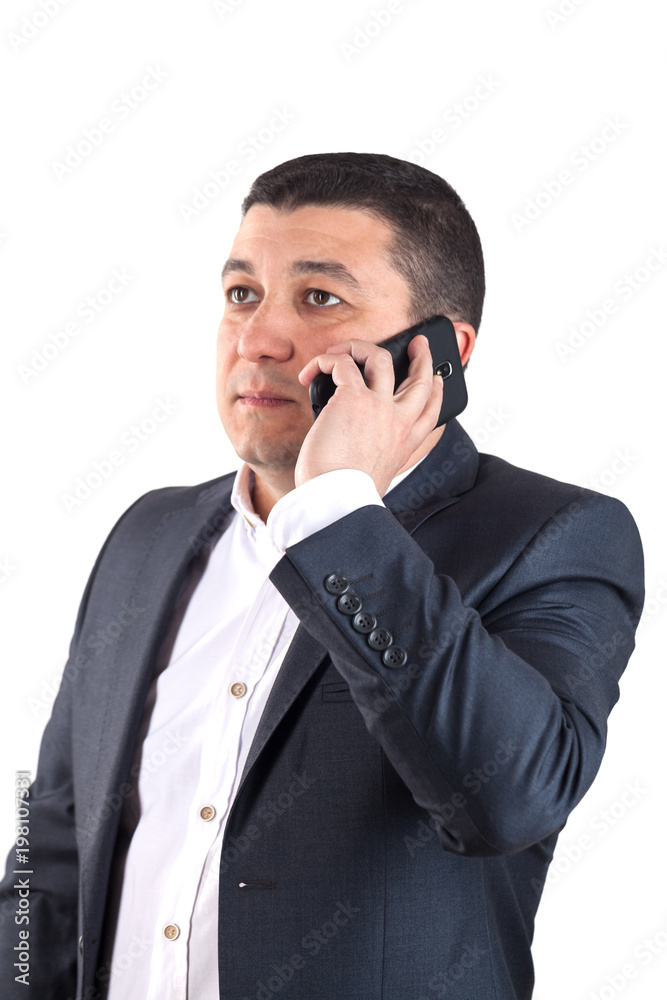 Portrait of a young man dressed in a white shirt and black suit, which speaks on the mobile. Isolated on white Portrait of a young man dressed in a white shirt and black suit, which speaks on the mobile. Isolated on white