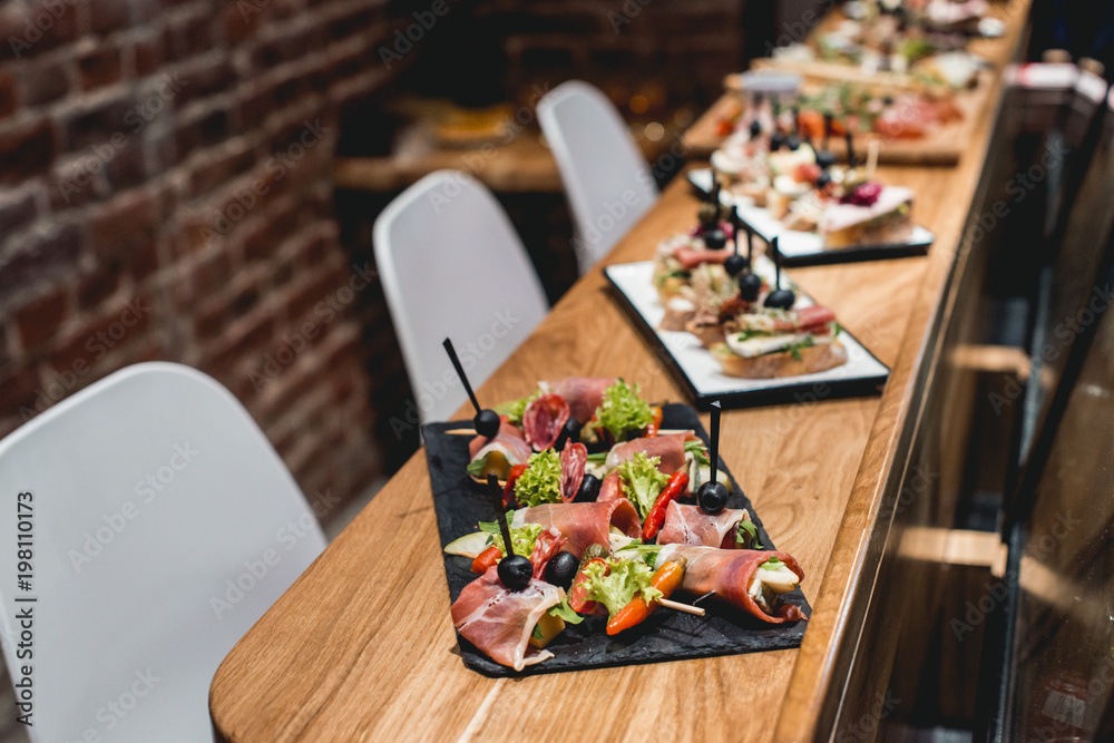 Φωτογραφία tasty pinchos with tuna, chorizos, salmon, egg, dried tomatoes, avocado, salmon,