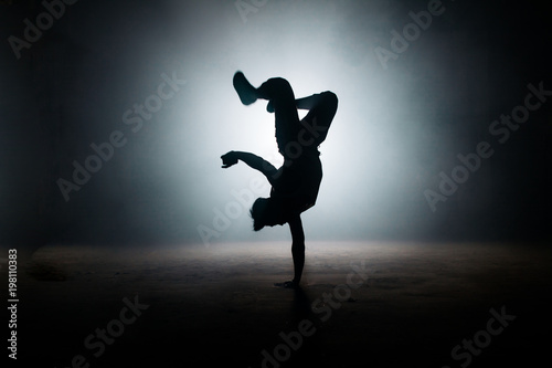 b-boy performing kick on yhe dark street. stylish position. dance form