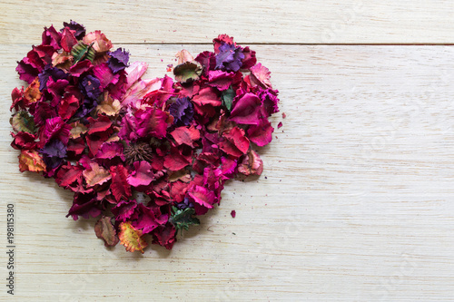 beautiful and aroma of dried flower petals many  shape heart on wood background with concept valentine day.